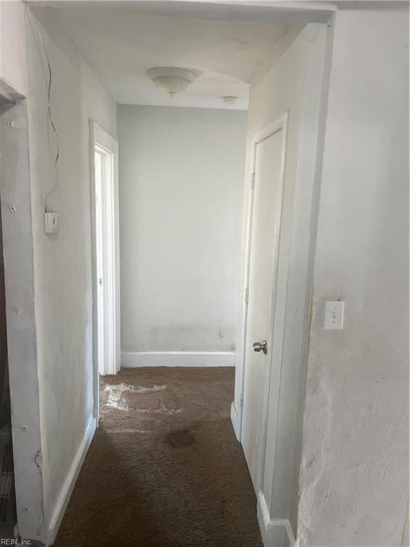 hallway with carpet and baseboards