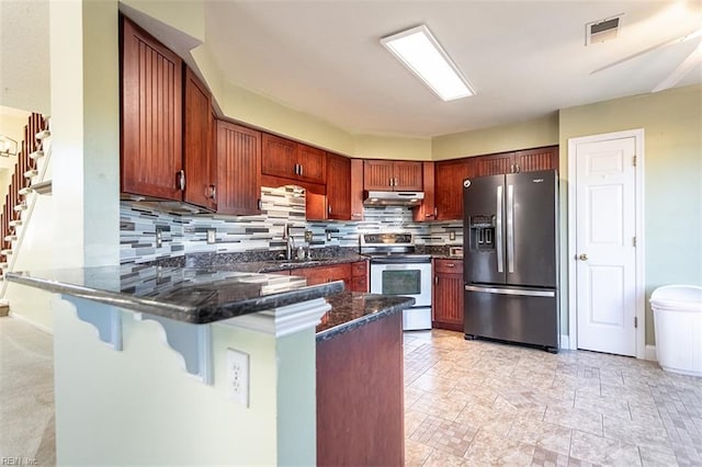 kitchen featuring backsplash, kitchen peninsula, a kitchen bar, appliances with stainless steel finishes, and dark stone counters