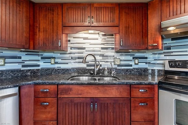 kitchen with backsplash, appliances with stainless steel finishes, sink, and dark stone counters