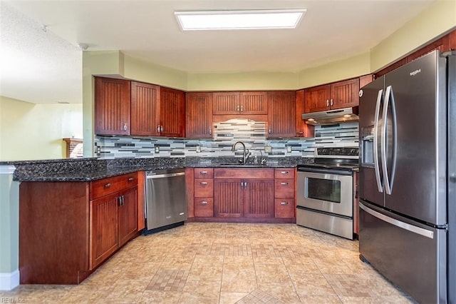 kitchen with backsplash, appliances with stainless steel finishes, sink, and dark stone countertops