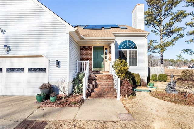 view of front facade with solar panels and a garage