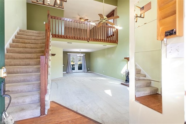 interior space featuring ceiling fan, carpet, a towering ceiling, and french doors