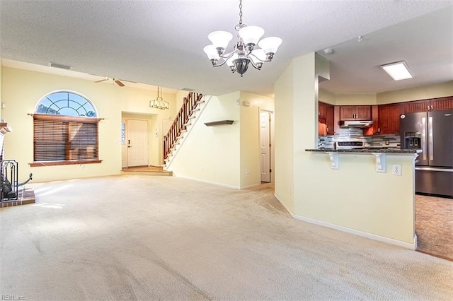 unfurnished living room with light carpet, an inviting chandelier, and a textured ceiling