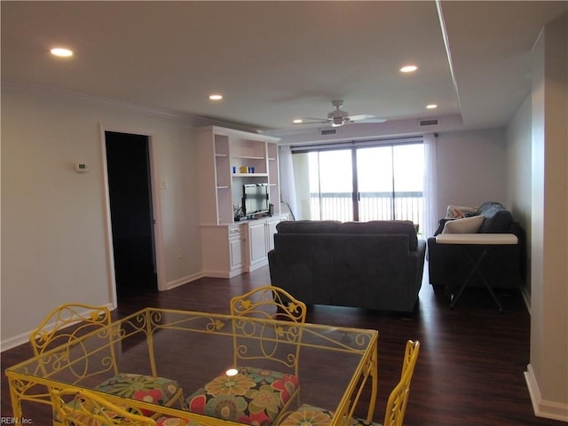 living room featuring ceiling fan, dark wood-type flooring, and crown molding