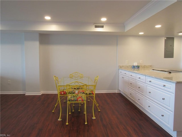 dining room with electric panel, ornamental molding, and dark hardwood / wood-style flooring