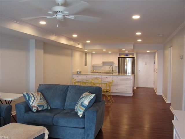 living room with ceiling fan, sink, dark hardwood / wood-style floors, and crown molding