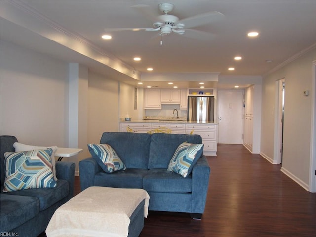 living room with ceiling fan, dark wood-type flooring, sink, and ornamental molding