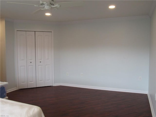 unfurnished bedroom with ceiling fan, crown molding, dark hardwood / wood-style floors, and a closet