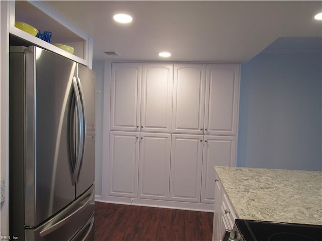 kitchen with white cabinets, dark hardwood / wood-style flooring, and stainless steel refrigerator