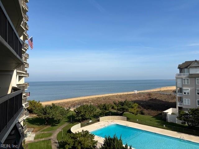 view of swimming pool with a beach view and a water view