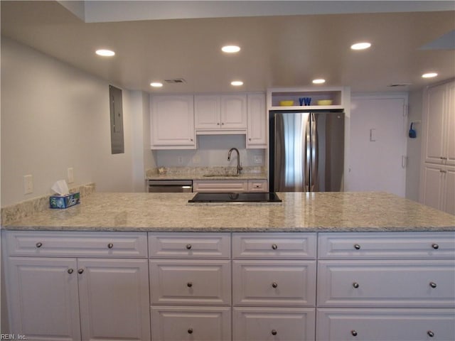 kitchen with white cabinets, light stone countertops, sink, and stainless steel appliances