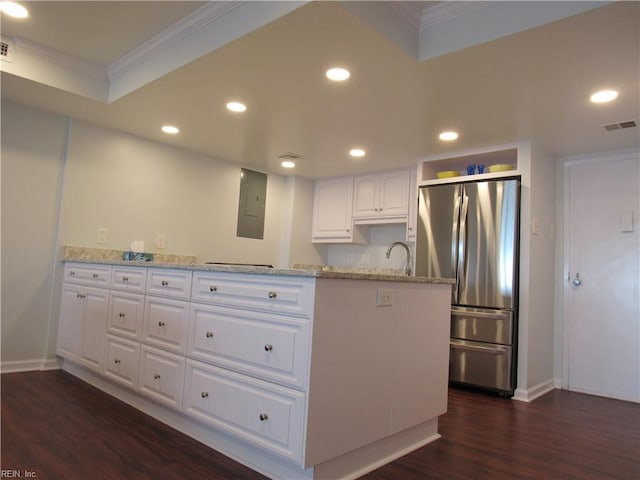 kitchen with light stone countertops, stainless steel fridge, white cabinetry, and ornamental molding