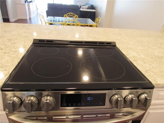 room details with light stone countertops and stainless steel electric range oven