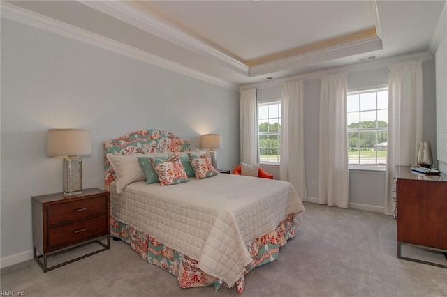 carpeted bedroom featuring crown molding, a tray ceiling, and multiple windows