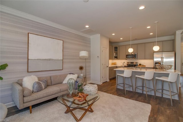 living room with dark wood-type flooring and crown molding