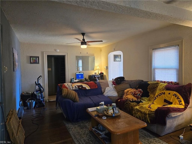 living room with ceiling fan, dark wood-type flooring, and a textured ceiling