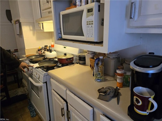 kitchen with ventilation hood, white cabinetry, and white appliances