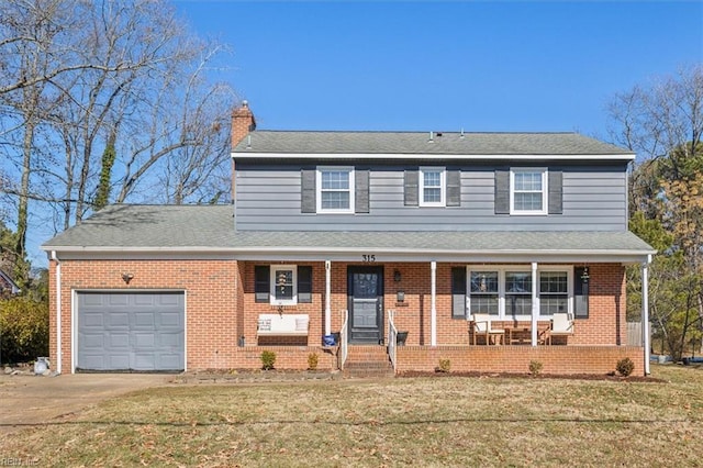 view of front property featuring a front yard, a garage, and a porch