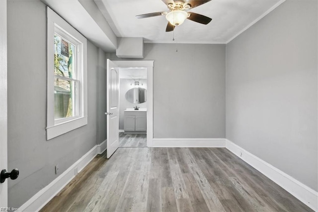 unfurnished room featuring light wood-type flooring, ceiling fan, and sink