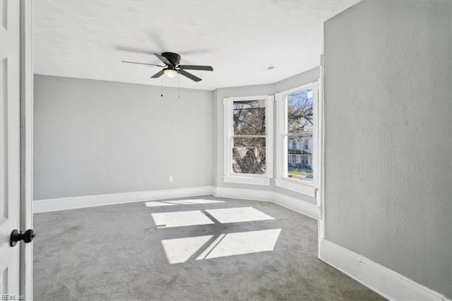 unfurnished room with ceiling fan and carpet