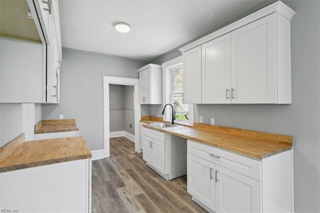 kitchen featuring sink, white cabinets, and butcher block counters