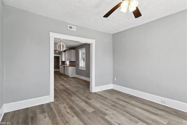 unfurnished living room featuring ceiling fan and hardwood / wood-style floors