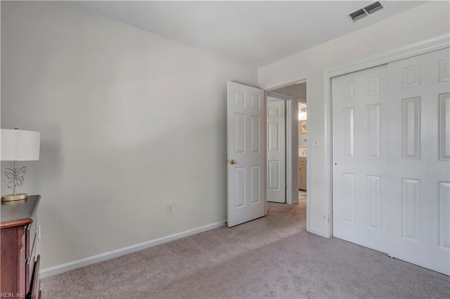 unfurnished bedroom featuring light carpet and a closet