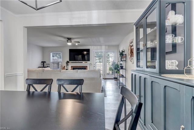 dining room featuring wood-type flooring, ornamental molding, and ceiling fan