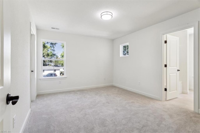 unfurnished room featuring a healthy amount of sunlight and light colored carpet