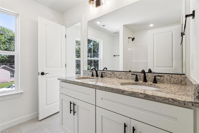 bathroom with tile patterned floors, vanity, and walk in shower