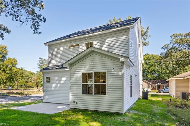 rear view of property with central AC, a lawn, and a patio