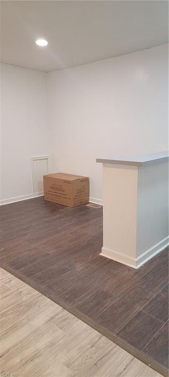 interior space with baseboards, wood finished floors, and recessed lighting