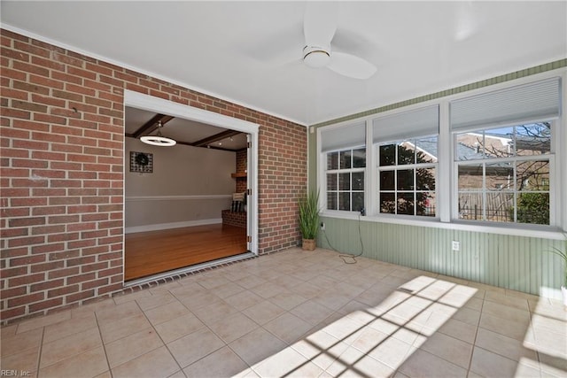 unfurnished sunroom with ceiling fan