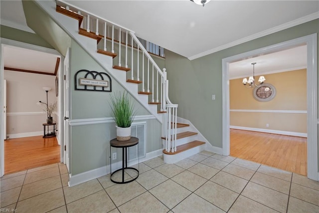 stairway with crown molding, tile patterned floors, and a notable chandelier