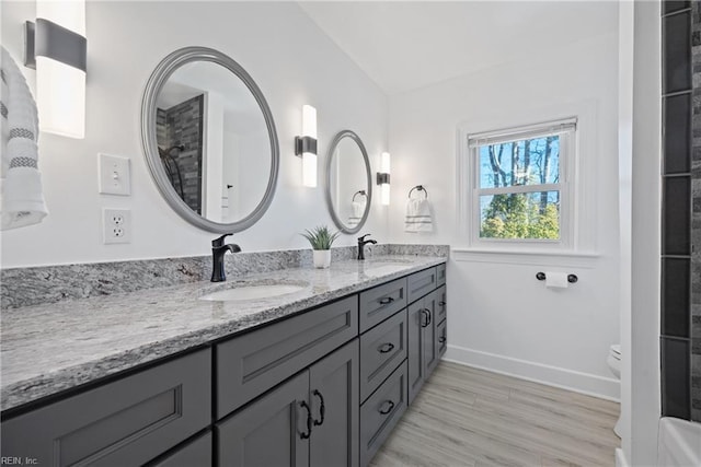 bathroom featuring hardwood / wood-style floors, toilet, vanity, and vaulted ceiling