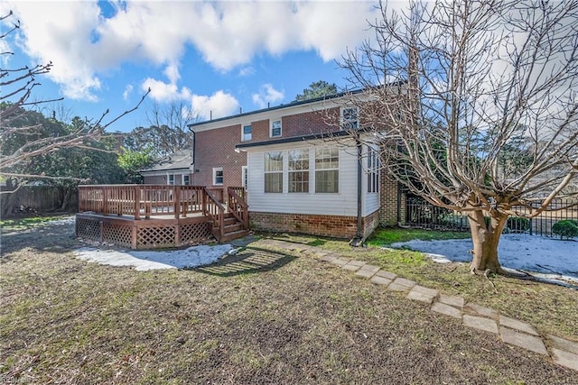 rear view of house with a deck and a yard