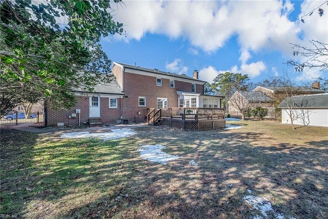 back of property with a shed, a yard, and a wooden deck