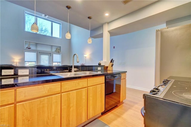 kitchen featuring pendant lighting, sink, dishwasher, and light wood-type flooring