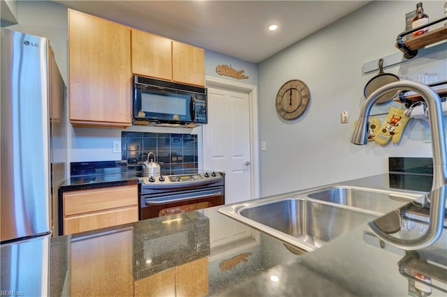 kitchen featuring sink, appliances with stainless steel finishes, light brown cabinetry, decorative backsplash, and dark stone counters