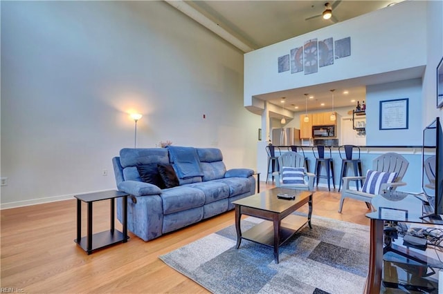 living room with light hardwood / wood-style floors and a high ceiling