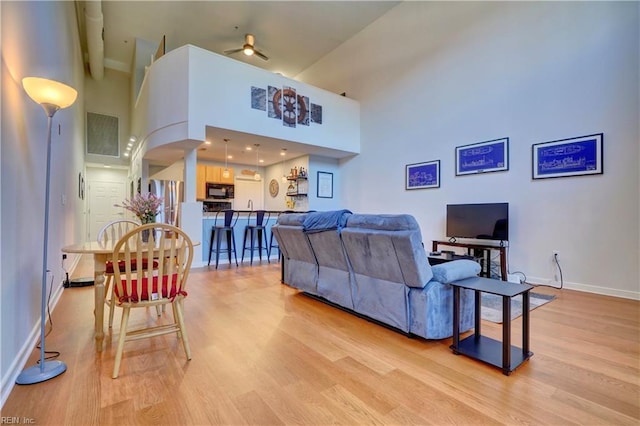 living room featuring light hardwood / wood-style floors and a high ceiling