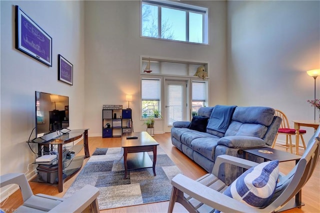 living room featuring light hardwood / wood-style floors and a high ceiling