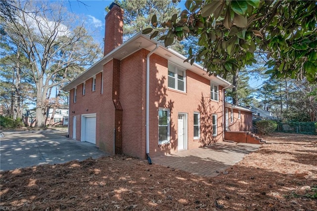 view of property exterior with a garage and a patio area