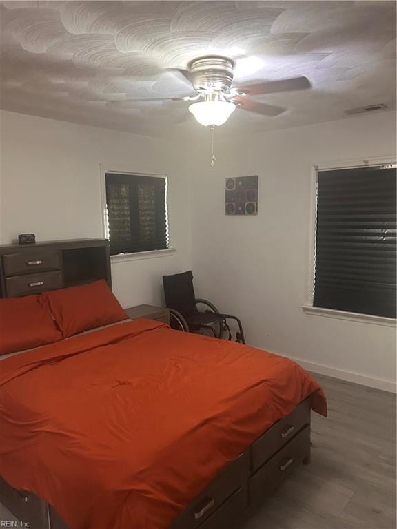 bedroom with ceiling fan and hardwood / wood-style flooring