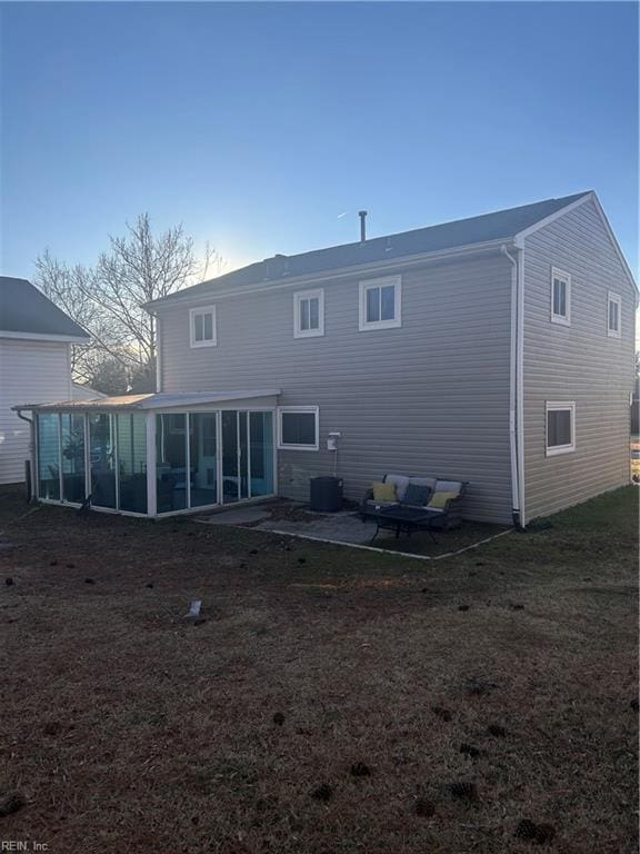 rear view of house with a sunroom and a yard