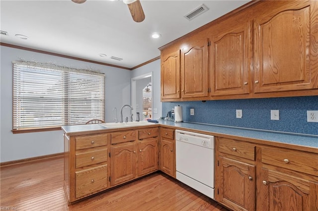 kitchen featuring dishwasher, sink, decorative backsplash, light hardwood / wood-style floors, and kitchen peninsula