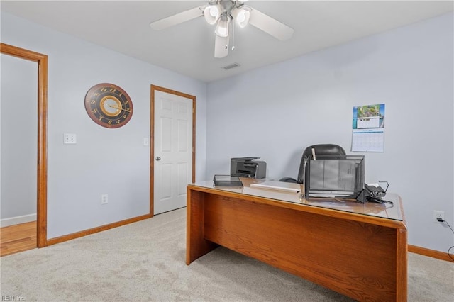 unfurnished office featuring ceiling fan and light colored carpet