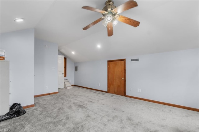 unfurnished living room with ceiling fan, light colored carpet, and lofted ceiling