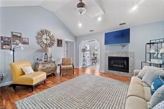 living room featuring ceiling fan, wood-type flooring, and vaulted ceiling