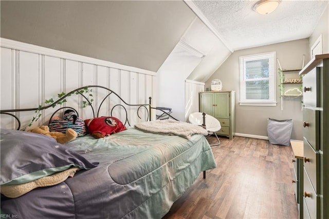 bedroom featuring a textured ceiling, lofted ceiling, and hardwood / wood-style floors